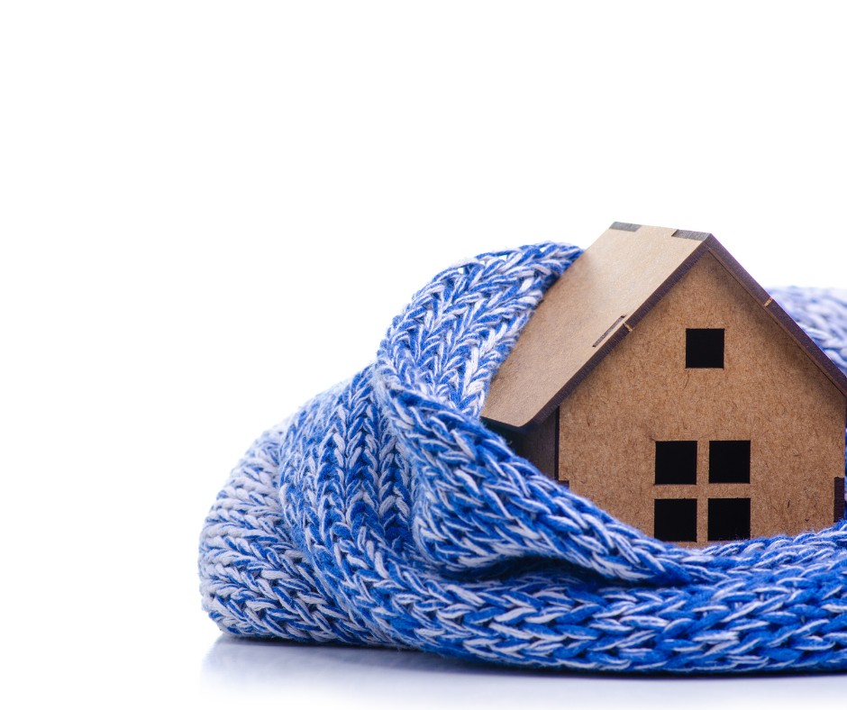 Ein in eine blaue Decke gehülltes Haus, das nach dem Gebäudeenergiegesetz einer Sanierung unterzogen wird, auf dem ein Holzhaus als zusätzliche Wärme dient