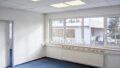 Perfekte Anbindung! Helle Büroflächen mit Fenstern und einem Heizkörper in einem leeren Büro.