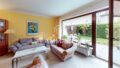 Ein Wohnzimmer mit gelben Wänden und einer Glasschiebetür in einem Endreihenhaus.