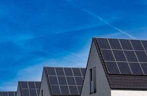 contemporary homes featuring solar panels under a bright blue sky promoting renewable energy.